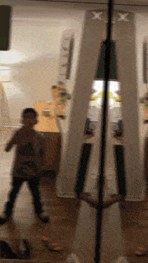 a boy is standing in front of a mirror with a x on it