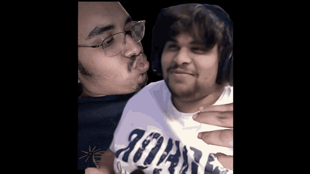 a man wearing a shirt that says ' jordan ' on it kisses another man on the cheek