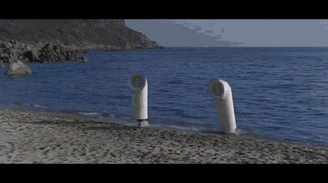 a couple of speakers on a beach near the water