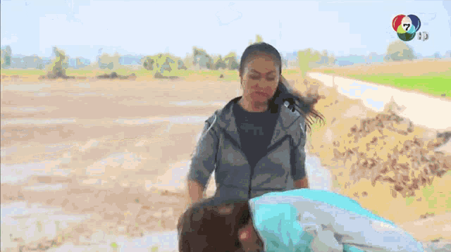 a woman standing next to another woman in a field with the number 7 on the screen