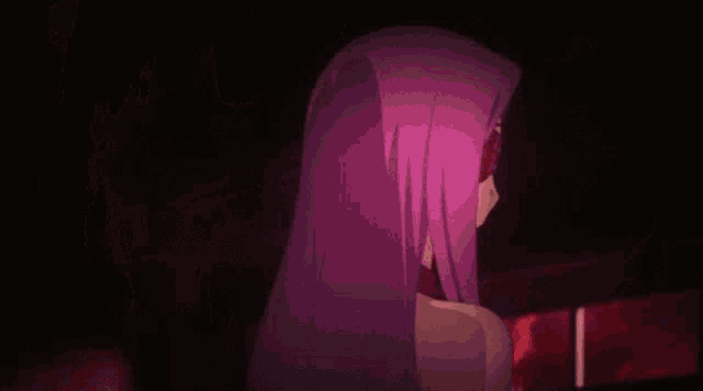 a woman with purple hair and sunglasses on her eyes is standing in the dark .