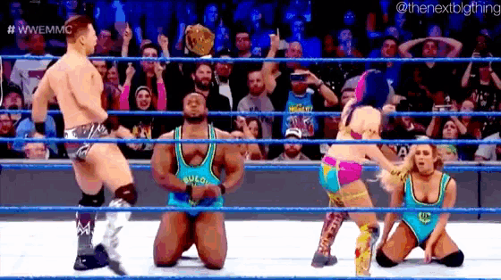 a group of wrestlers are kneeling down in a ring .
