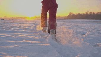 a person in a red snow suit is jumping in the snow
