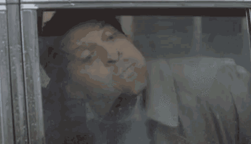 a man is laying in a car with his mouth wide open