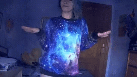 a woman wearing a sweater with a galaxy design on it
