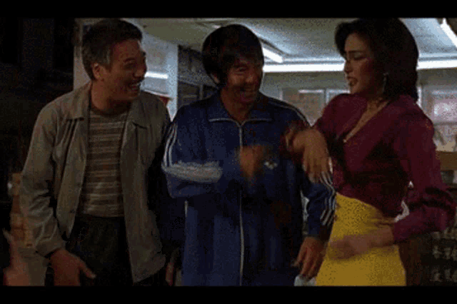 a woman in a yellow skirt is dancing in front of two men