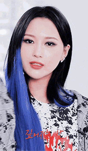 a woman with blue hair is wearing a t-shirt that says ' nirvana ' on it