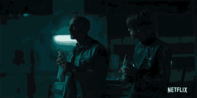 two men standing in a dark room with netflix written on the bottom