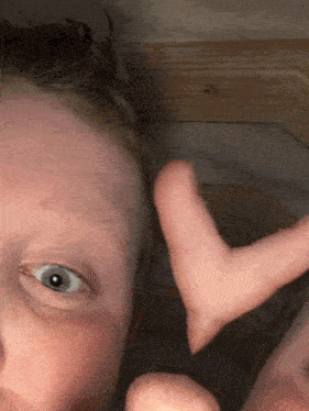 a close up of a person making a heart shape with their finger