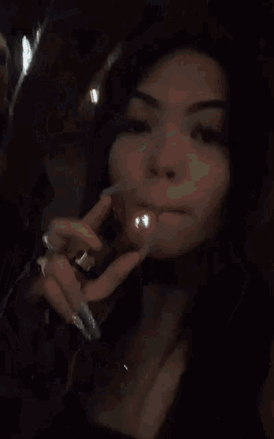 a woman in a black tank top giving the middle finger