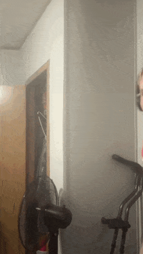 a person standing in a room with a fan in front of them