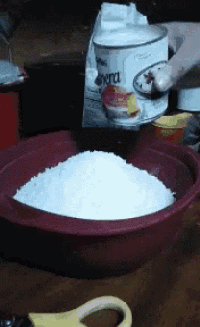 a red bowl filled with white powder next to a bag of sierra