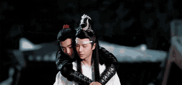 two men are hugging each other and one of them is wearing a crown .