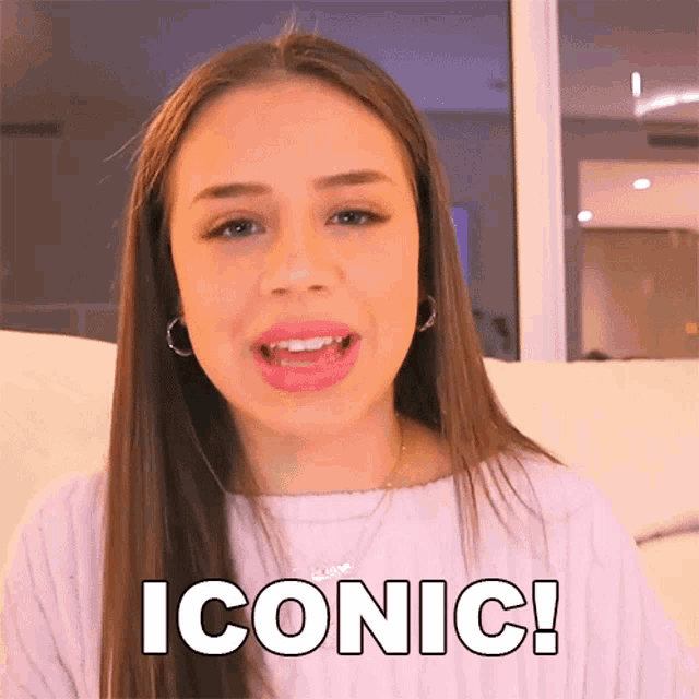 a young woman is sitting on a couch with the word iconic written on her face