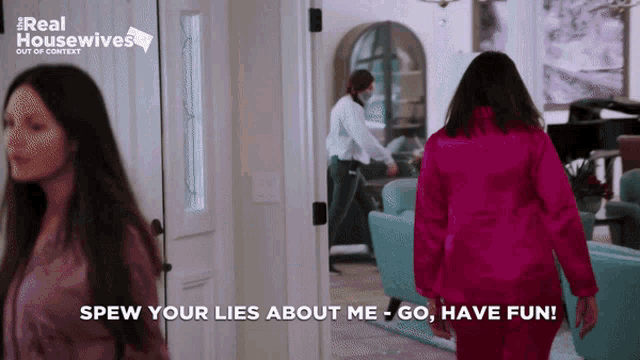 a woman in a pink jacket is walking down a hallway with the words spew your lies about me go have fun