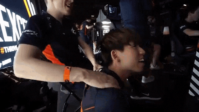 a man is hugging another man in front of a sign that says exit on it