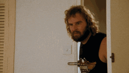 a man with a beard is standing in a doorway with the words that hurts me behind him