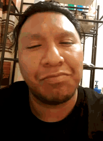 a man with his eyes closed and a beard is smiling