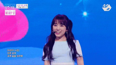 a girl in a blue shirt is smiling on a stage in front of a m logo