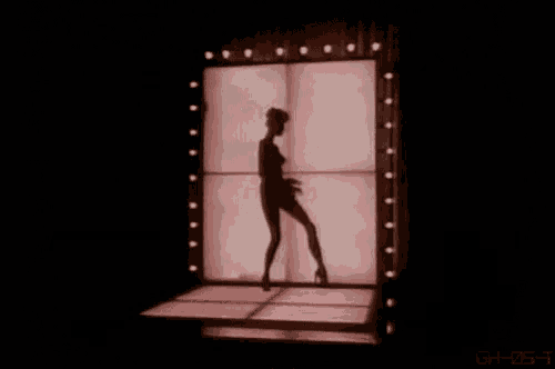 a skeleton is dancing on a stage in front of a red curtain .