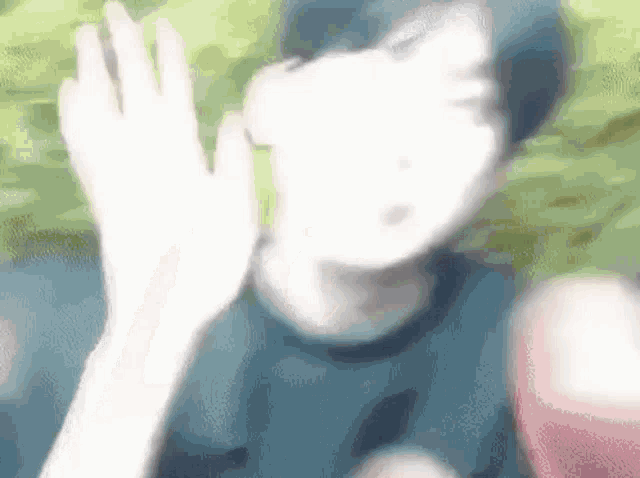 a blurry picture of a person waving their hand in the air .