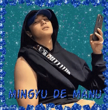 a man in a hoodie and hat is taking a selfie with his phone .