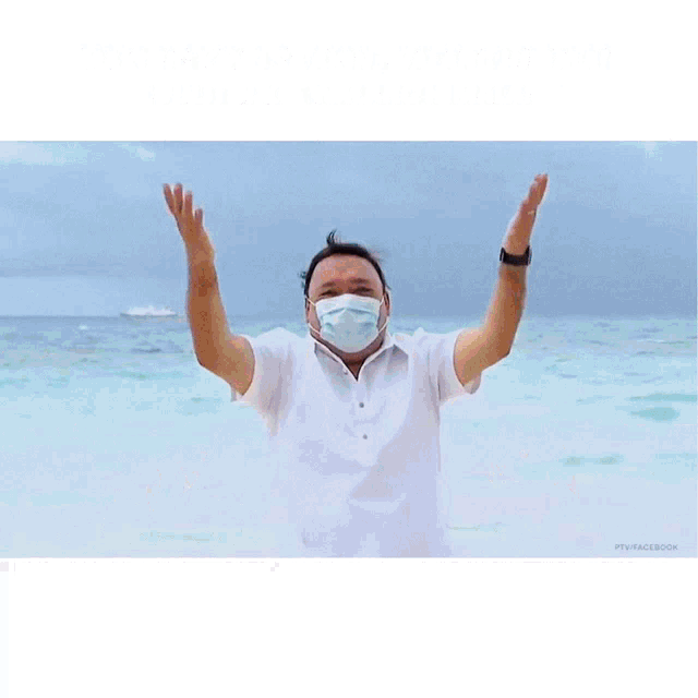a man wearing a face mask is standing on a beach next to a cartoon character