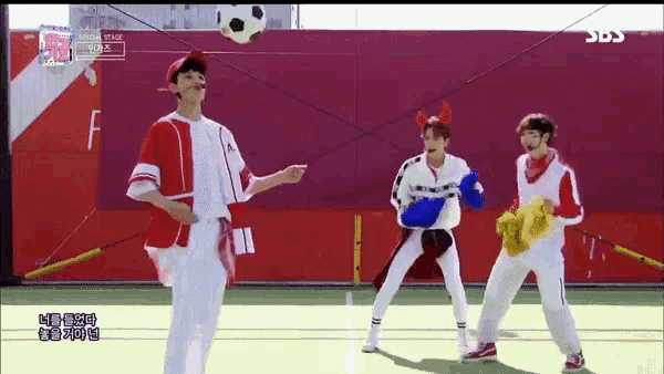 a group of people are standing on a soccer field with a soccer ball in the air .