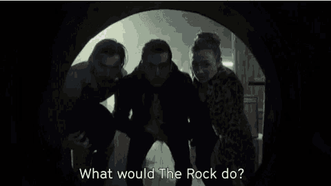 a group of people are standing next to each other in a tunnel and talking .