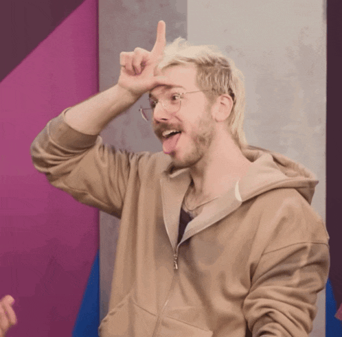 a man with blonde hair and glasses is making a funny face