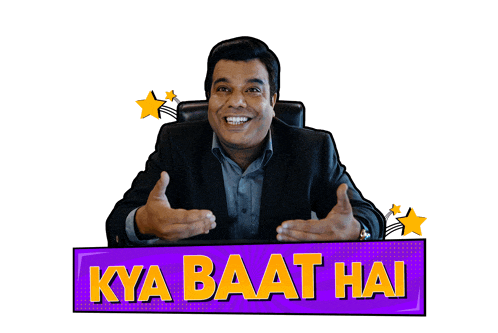 a man in a suit sits behind a sign that says " kya baat hai "