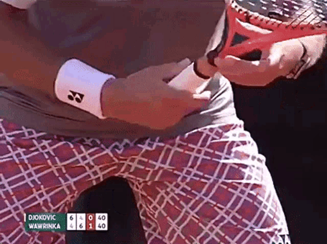 a tennis player named djokovic is holding a tennis racquet in his hand