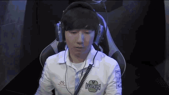 a man wearing headphones and a white shirt with the word wings on it