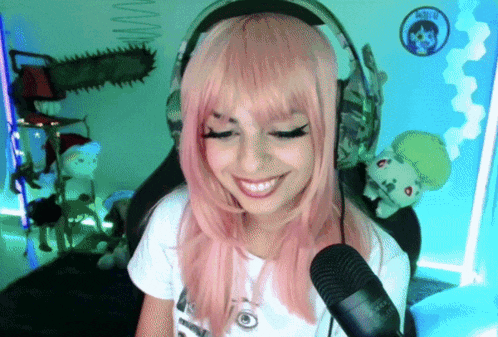 a girl with pink hair and headphones is smiling