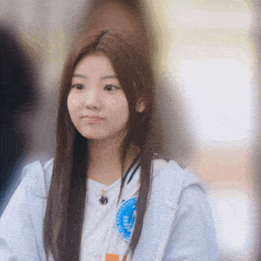 a girl wearing a white shirt with a blue circle on it that says ' ucsd ' on it