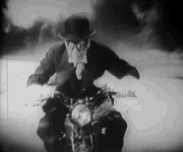 a man in a suit is riding a motorcycle