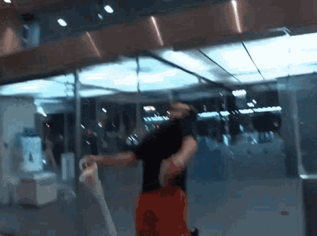 a man in a black shirt and red shorts is standing in front of a glass door