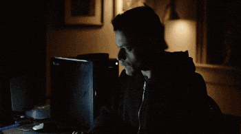 a man sitting at a desk with a lamp on