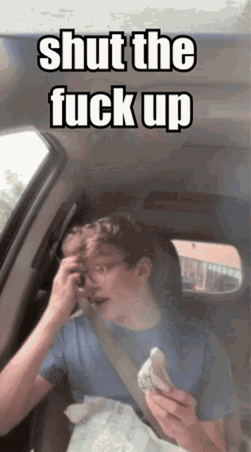 a man sitting in a car with the words shut the fuck up