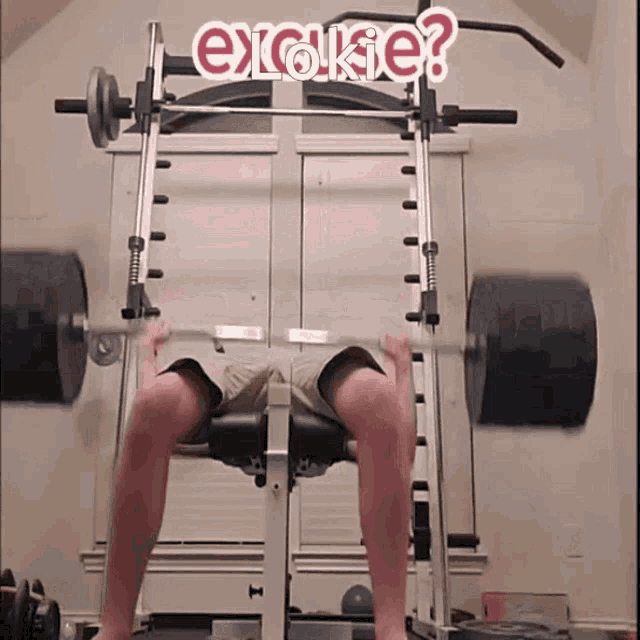 a man is lifting a barbell on a bench with the words erokie written on the wall behind him