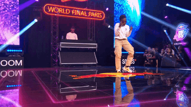 a man dancing on a stage with a sign that says world final paris