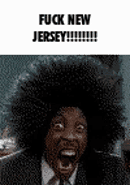 a man in a suit and tie is screaming with his mouth open and a big afro .