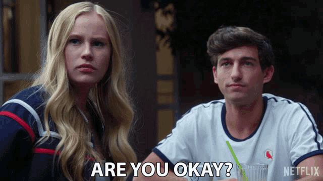 a man and a woman are sitting next to each other and the man is asking the woman if she is okay