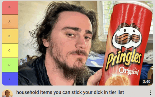 a man with a beard holds a can of pringles