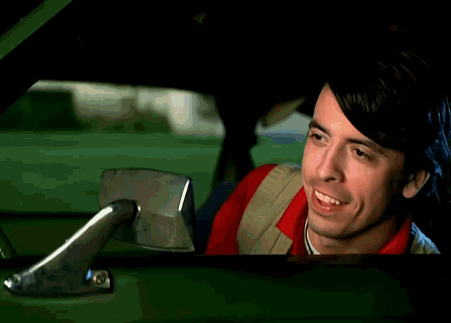 a man is laughing while sitting in a car
