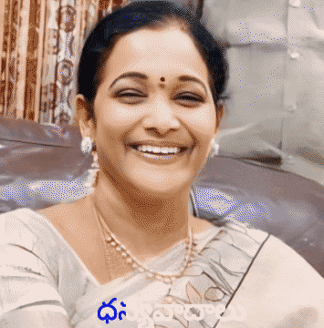 a woman wearing a pearl necklace and earrings smiles for the camera with a foreign language written on the bottom