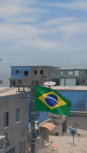 a brazilian flag is hanging from a pole in a small town
