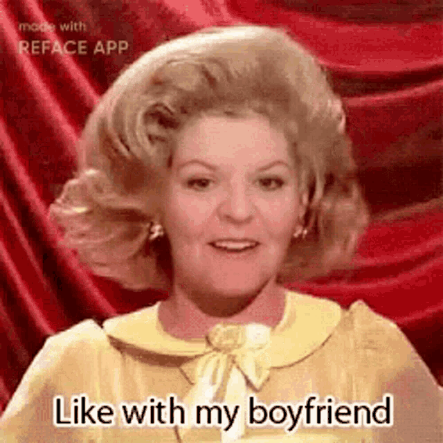 a woman in a yellow dress is standing in front of a red curtain and says `` like with my boyfriend '' .
