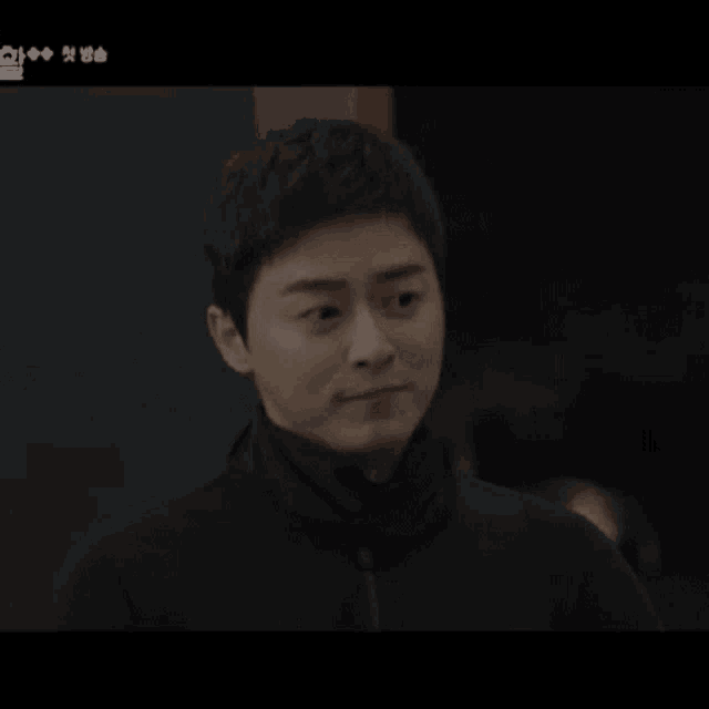 a man in a black jacket is making a funny face .