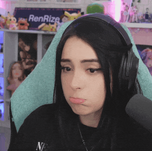a woman wearing headphones is sitting in front of a sign that says renrize on it